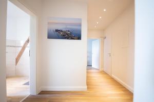 a hallway with white walls and a painting on the wall at Ferienwohnung BEA 2 in Rabenkirchen-Faulück