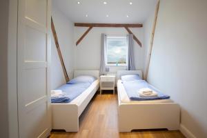 two beds in a room with a window at Ferienwohnung BEA 2 in Rabenkirchen-Faulück