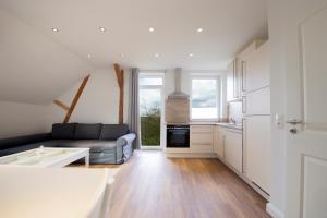 a living room with a couch and a kitchen at Ferienwohnung BEA 2 in Rabenkirchen-Faulück