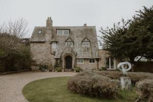 an old stone house with a statue in front of it at Florence House Bed & Breakfast in Seaford