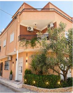 an apartment building with a balcony and a tree at Appartement chic et luxueux in Rejiche