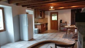 a kitchen with a refrigerator and a table with chairs at Logis de Rocles in Rocles