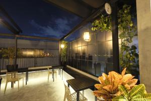 a balcony with a table and chairs and a clock at Ceci House - Santa Cecília in São Paulo
