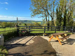 a wooden picnic table sitting next to a fence at Hyssington Heights in Hyssington