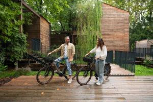 a man and a woman riding bikes on a boardwalk at Terme Preistoriche Resort & Spa in Montegrotto Terme