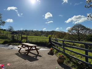 a wooden picnic table sitting next to a fence at Hyssington Heights in Hyssington