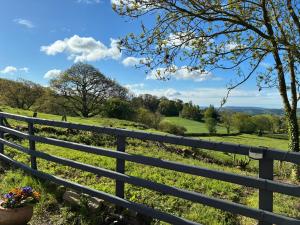 a fence with a view of a field at Hyssington Heights in Hyssington