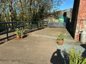a fence with potted plants next to a sidewalk at Hyssington Heights in Hyssington +27 photos