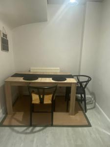 a wooden table with two chairs sitting next to a room at Private room with private bathroom in Hackington