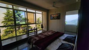 a bedroom with a bed and a large window at ONHILLs in Mussoorie +7 photos