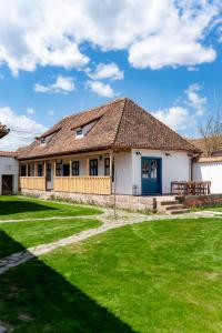 a house with a green lawn in front of it at Gabri Guesthouse Transylvania in Aita Seacă