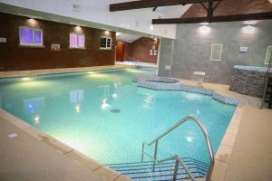 a large swimming pool in a building at Best Western Bolholt Country Park Hotel in Bury
