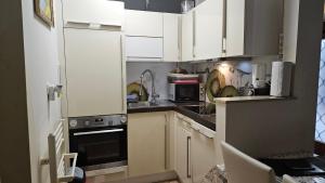 a small kitchen with white cabinets and appliances at Apartment Sara in Koper