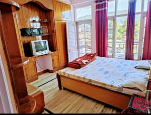 a bedroom with a bed and a tv and a window at Ghar Family-Homestay- 2 Room -Prime Location - Balcony kitchen-Don't book Single Room Book a complete Home in Solan