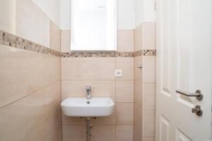 a white sink in a bathroom with a window at Ferienwohnung BEA 1 in Rabenkirchen-Faulück