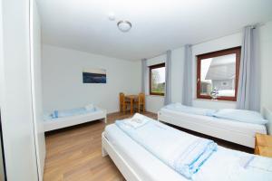 two beds in a room with two windows at Ferienwohnung BEA 1 in Rabenkirchen-Faulück +4 photos