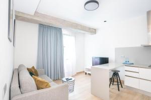 a white living room with a couch and a table at URBANSEA Las Palmas in Las Palmas de Gran Canaria