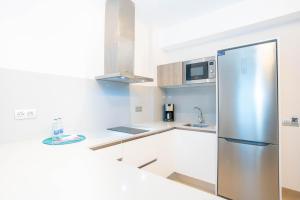 a stainless steel refrigerator in a white kitchen at URBANSEA Las Palmas in Las Palmas de Gran Canaria