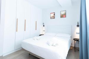 a bedroom with a white bed with white cabinets at URBANSEA Las Palmas in Las Palmas de Gran Canaria +9 photos