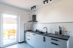 a kitchen with white cabinets and a sink and a window at Morski Resort in Ustka