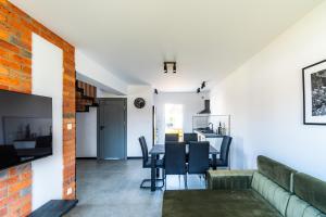a living room and dining room with a table and chairs at Morski Resort in Ustka