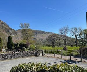 a fence in a field with mountains in the background at The New Inn in Oswestry