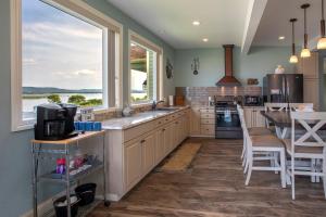 a kitchen with a large window and a table with chairs at Riverview, 5BR, Hot tub, Fireplace, Arcade Game in Minneiska