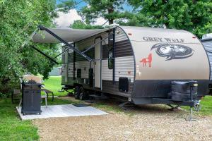 an rv with a tent on top of it at Big River Escape Riverside Cabins in Buffalo City