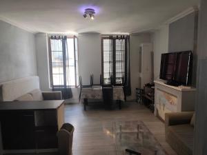 a living room with a couch and a tv at superbe t2 centre de cognac in Cognac