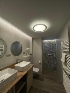 a bathroom with two sinks and a shower with a mirror at Apartamente Baile Felix in Baile Felix +48 photos