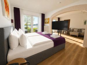 a hotel room with a large bed and a television at Seehotel Schwanenhof in Mölln