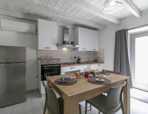 a kitchen with a wooden table with chairs around it at Zia Elisa Mare e Comfort - Tertenia in Tertenìa