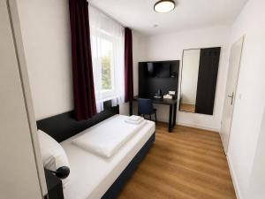 a bedroom with a bed and a desk and a mirror at Seehotel Schwanenhof in Mölln +44 photos