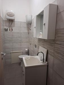 a small bathroom with a sink and a mirror at il PORTICO in Tertenìa