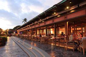 a restaurant with tables and chairs and people eating at Mauna Kea Beach Hotel, Autograph Collection in Hapuna Beach