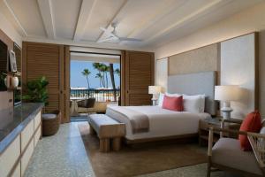 a hotel room with a bed and a balcony at Mauna Kea Beach Hotel, Autograph Collection in Hapuna Beach