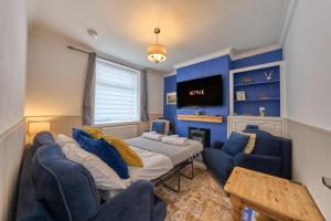 a living room with blue walls and a couch and chairs at Cosy Peak District Cottage Walk to Town Centre in Fairfield +41 photos