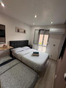 a bedroom with two beds and a table and a window at Habitaciones privadas in Madrid