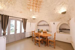 a kitchen and dining room with a wooden table and chairs at Pavì Trulli e Suites in Locorotondo