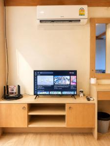 a flat screen tv sitting on top of a wooden entertainment center at VONLUCK-Wonnapha Beach in Ban Bang Saen (1)