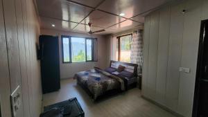a bedroom with a bed in a room with a window at ONHILLs in Mussoorie
