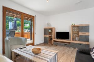 a living room with a table and a tv at Kleeblatt in Bad Wildbad