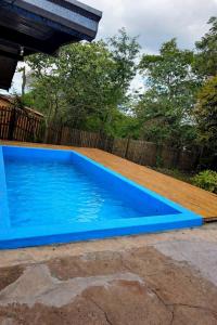 a blue swimming pool next to a wooden fence at El Refugio Misiones in Garupá