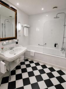 a bathroom with a white tub and a sink and a bath tub at Grand Palace Hotel - Small Luxury Hotels of the World in Riga