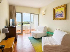 a living room with a couch and a bed and a television at Aparthotel Navigator in Sagres