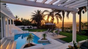 a backyard with a swimming pool and a house at Strode House in Knysna