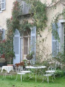 a table and chairs in front of a building at Chateau Chemilly in Chemilly