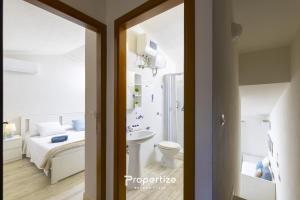 a bathroom with a bed and a sink and a toilet at Il terrazzo sulla duna 5 by Propertize in Marrùbiu +27 photos