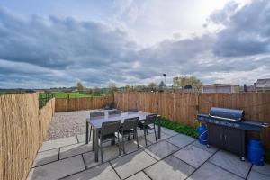 a patio with a table and chairs and a fence at Cosy Peak District Cottage Walk to Town Centre in Fairfield