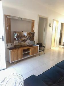 a living room with a large entertainment center with a television at Germinada in Imbé